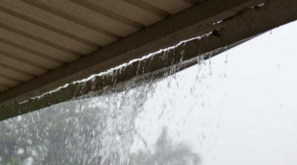 damaged roof gutter with water leaking