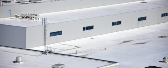 Light colored material is placed on commercial roof to comply with California cool roofing mandates