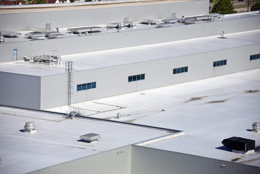 Light colored material is placed on commercial roof to comply with California cool roofing mandates