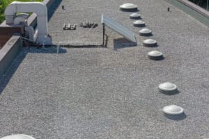 A built-up roofing system with a layer of protective gravel on top.