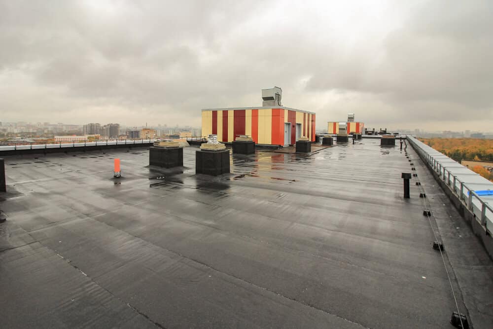 A waterproof roofing membrane on an industrial building on a rainy day.