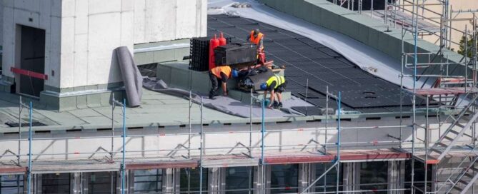A crew of roofing professionals installing a commercial roofing system