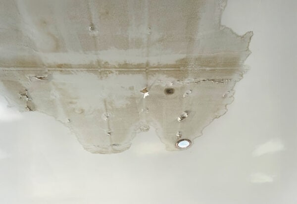 Interior water damage caused by commercial roof leaks, showing signs that a roof replacement may be needed instead of continued repairs