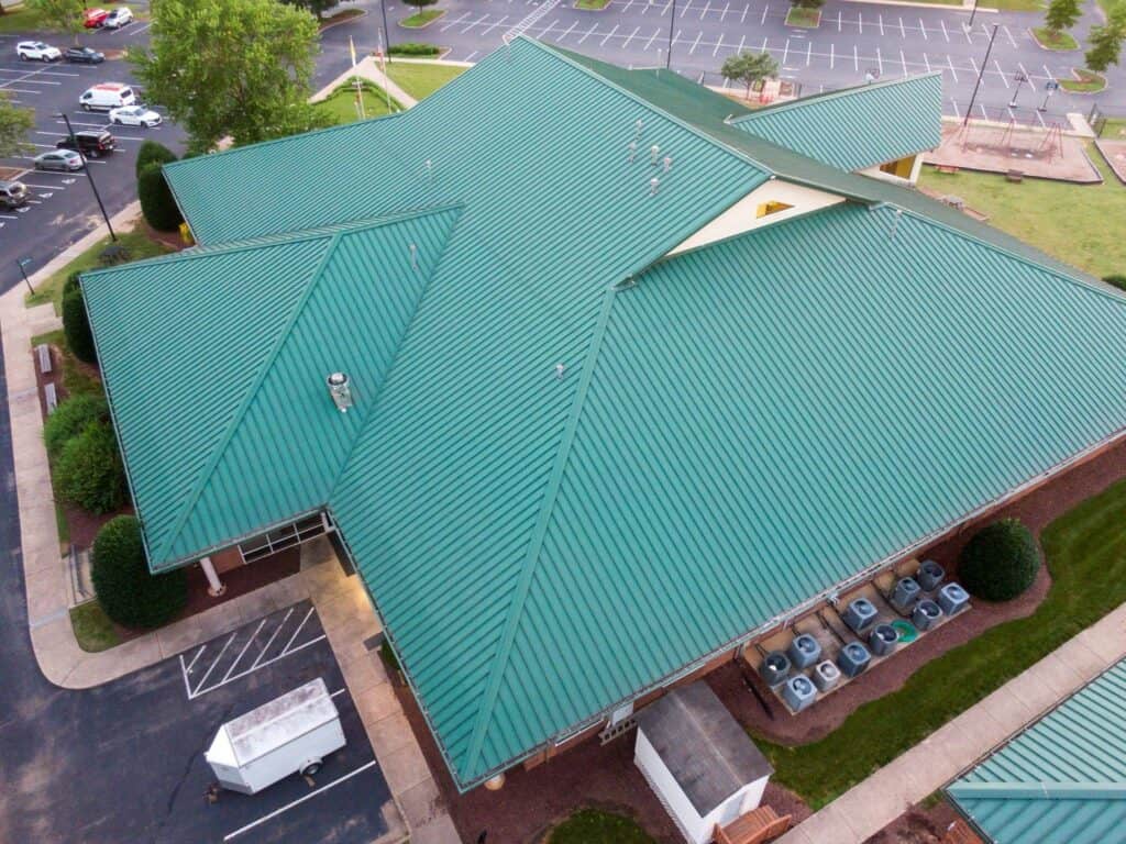 Green standing seam metal roof installed on a commercial building.